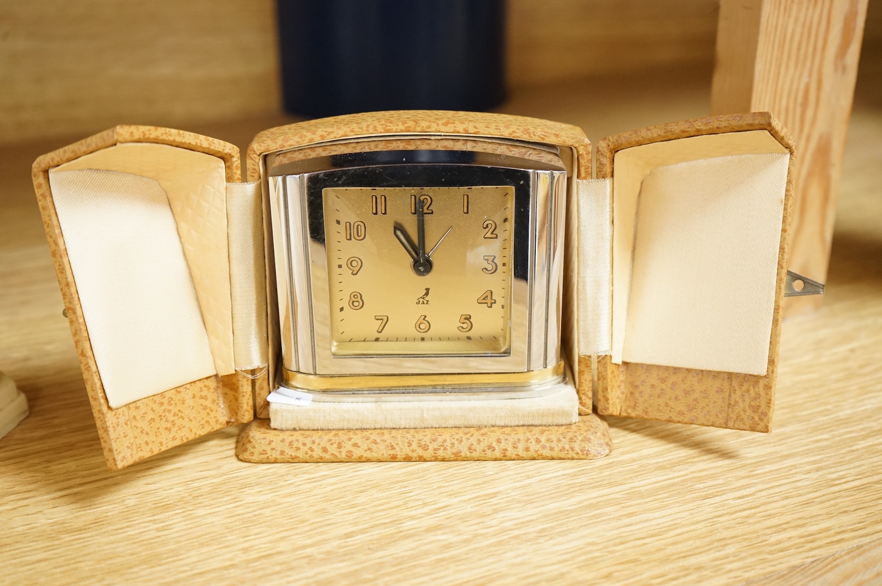 Two Art Deco timepieces comprising a Japy alarm clock and a Jas cased travelling example, largest 22cm wide